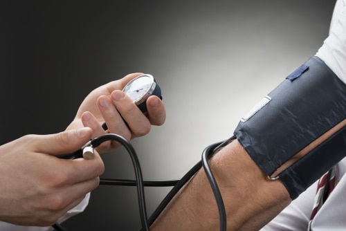 Close-up Of A Doctor's Hand Checking Blood Pressure Of A Patient