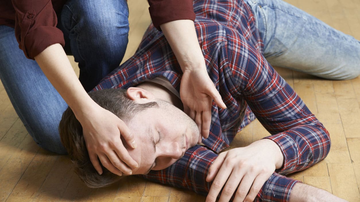 A Man Being Placed In Recovery Position After Accident