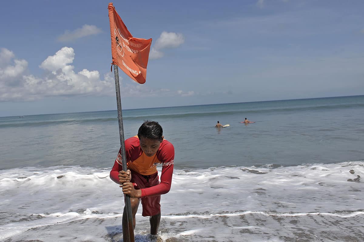 Petugas Badan Penyelamat Wisata Tirtha (Balawista) Kabupaten Badung memasang bendera rambu-rambu larangan berenang menyusul adanya seruan kewaspadaan dampak Tsunami Chili, di Pantai Kuta, Bali, Kamis (3/4). Badan Penanggulangan Bencana Daerah sebelumnya telah mengeluarkan himbauan bagi masyarakat da