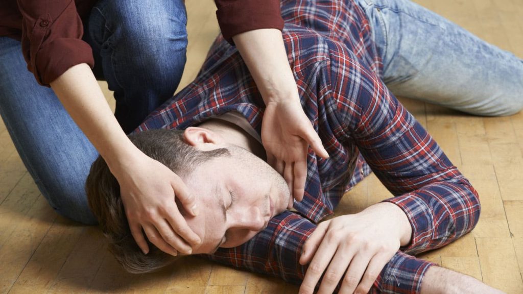 A Man Being Placed In Recovery Position After Accident